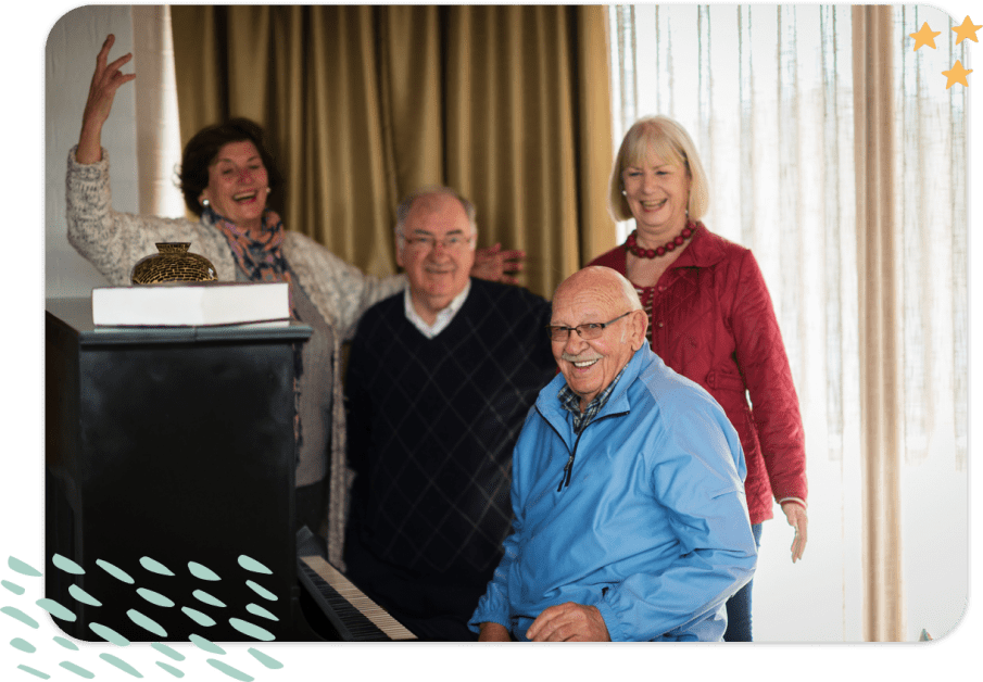 Group of happy seniors around a piano