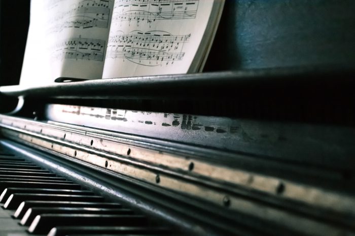 old black piano with sheet music